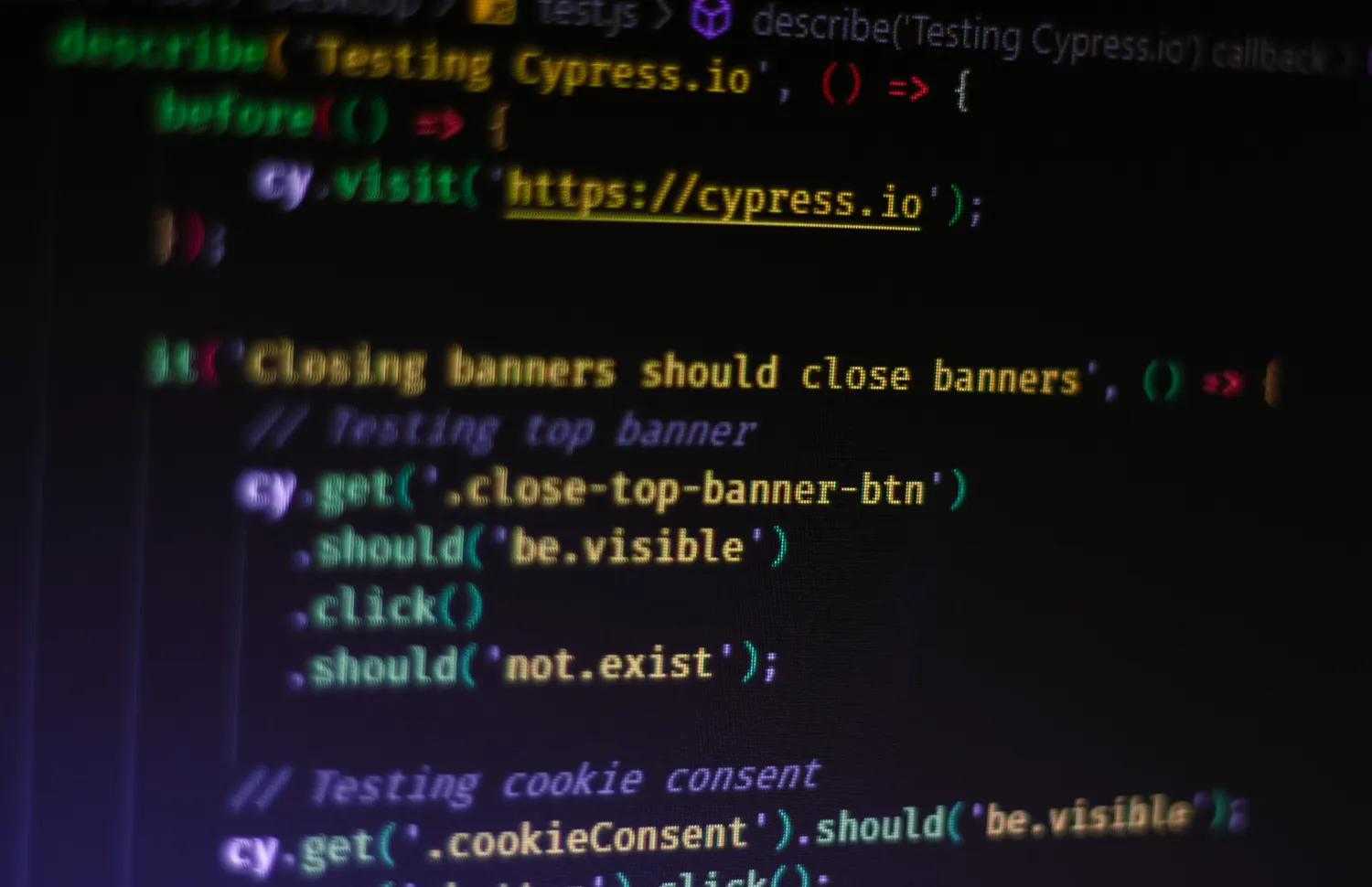 A close-up photograph of Cypress end-to-end test code displayed on a screen.