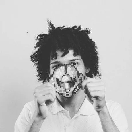 Robert Amarante holding a pixel-art face in front of his own
